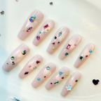 Decorative nails with colorful gemstones on a white background. luxury handmade press-on nail tips with Swarvoski. inspired by Bridgerton on Netflix