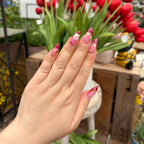 Vibrant handmade press-on nails from the Bloom & Glory collection featuring 3D white garden flowers, strawberry red polka dots