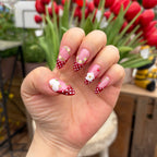 Vibrant handmade press-on nails from the Bloom & Glory collection featuring 3D white garden flowers, red polka dots, and strawberry 