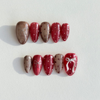 Handmade press-on nails in alternating ruby red and champagne glitter with white bows and polka dot accents.