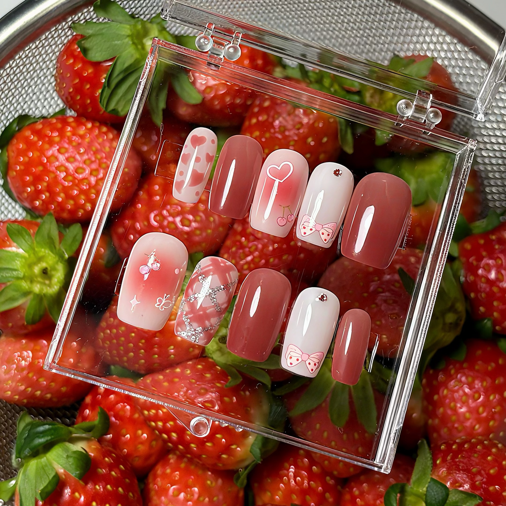 Handmade press-on nails with soft pink blush gradients, hand-painted cherries, and silver glitter heart details.