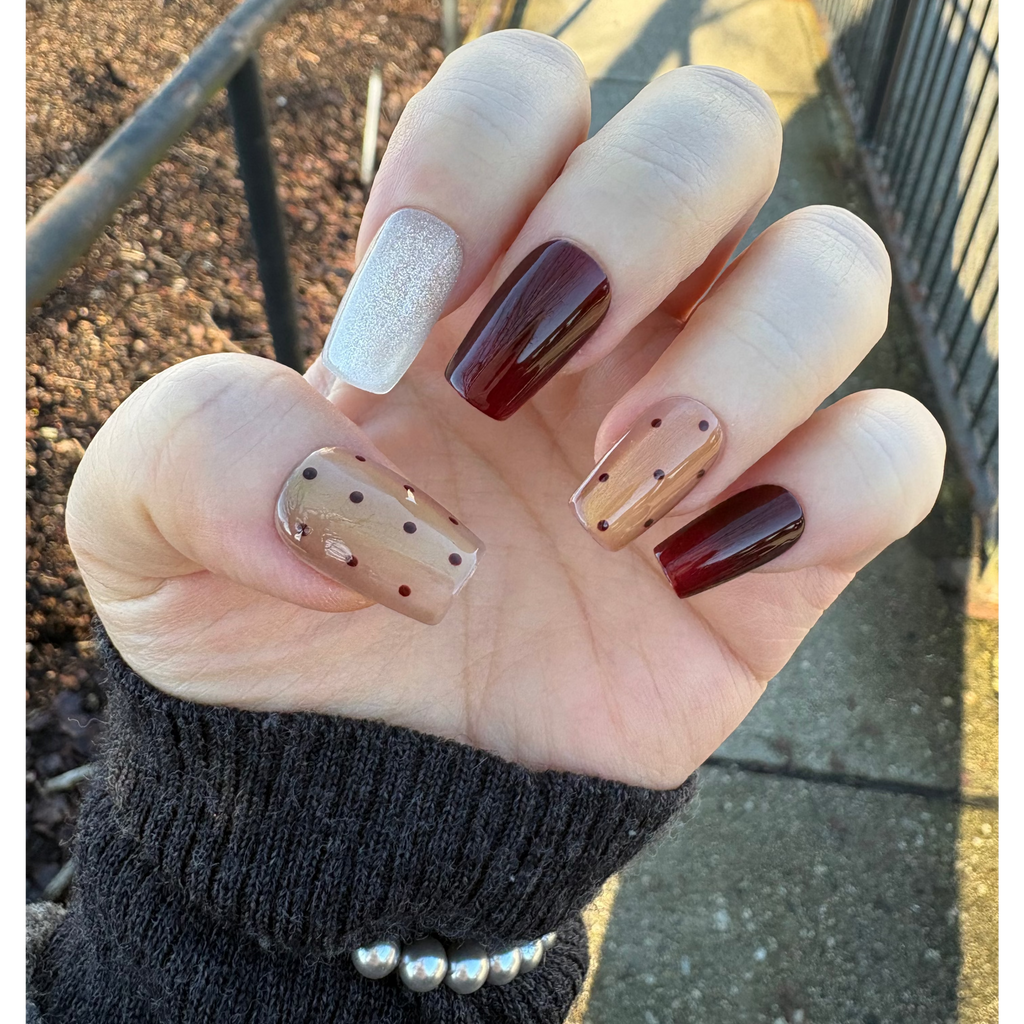 model display an elegant press on nail set with burgundy wine red, light brown with cat-eye and silvery glittery design. Polka dot