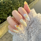 Hand with light-lemon yellow nails with dry flowers and hand drawing heart under spring sunshine