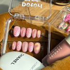 Close-up of the shimmering pearl encrusted nail and silver star accents on a pink velvet-effect gel base.