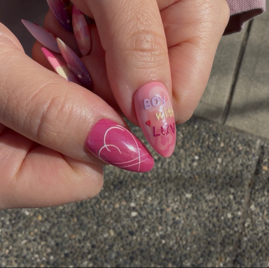 Close-up of the iridescent purple shimmer and hand-painted star motifs on a BTS-inspired nail set. Boy with luv
