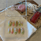 Handmade botanical press-on nails with 3D white lilies, hand-painted green leaves with pink veins, and 3D dewdrop accents.