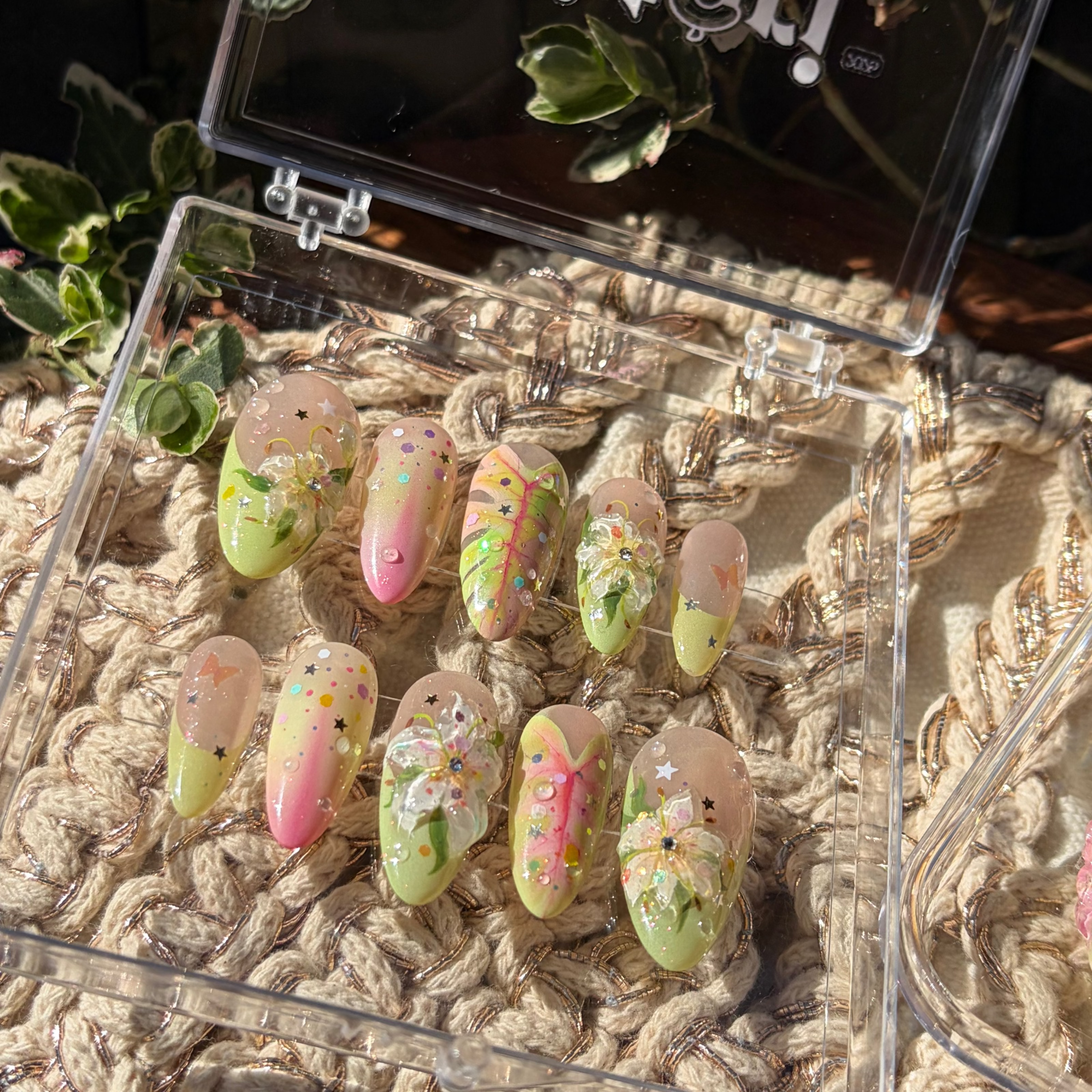 Handmade botanical press-on nails with 3D white lilies, hand-painted green leaves with pink veins, and 3D dewdrop accents.