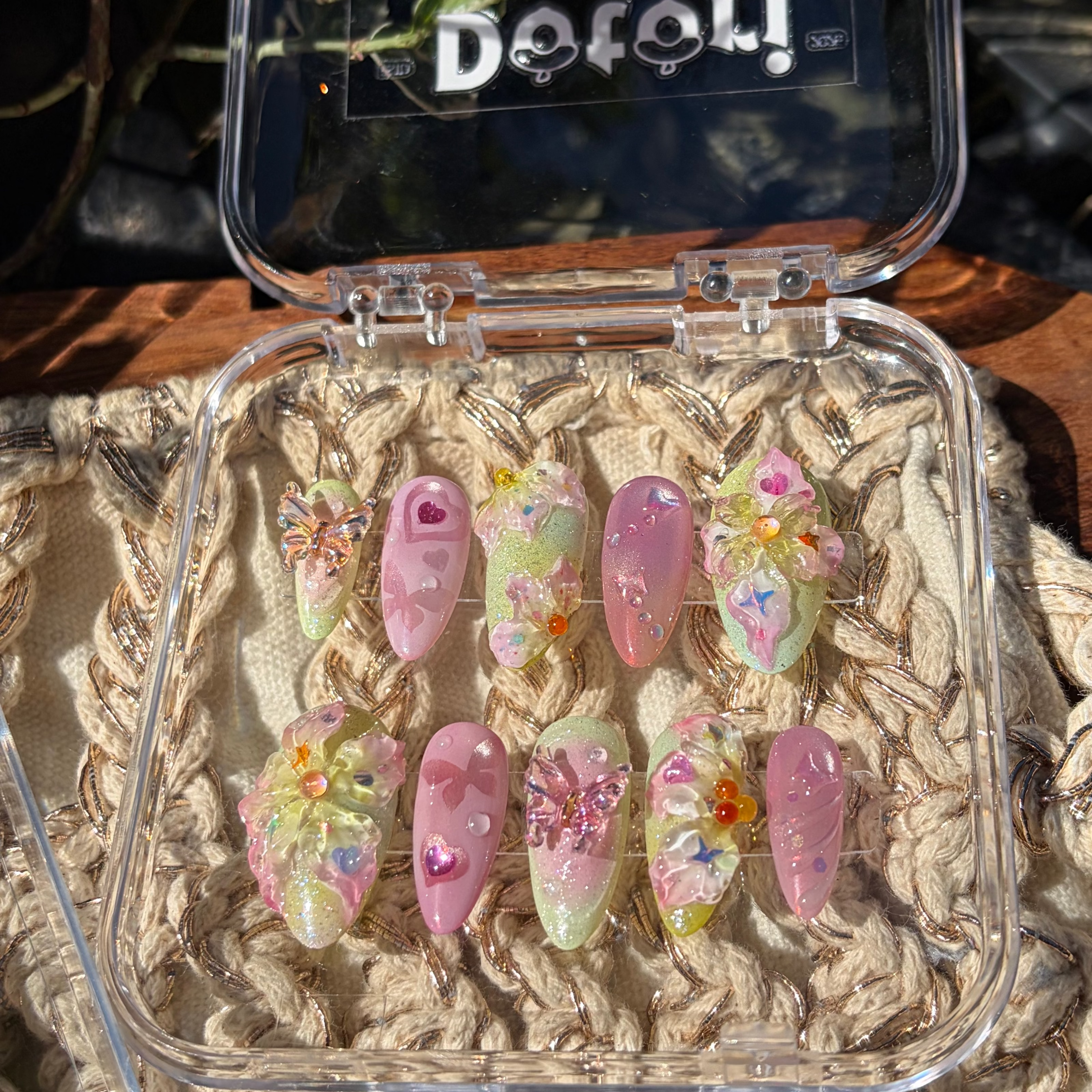 Handmade press-on nails in butter yellow and sage green with 3D white floral and butterfly charms and hand-painted leaf art.