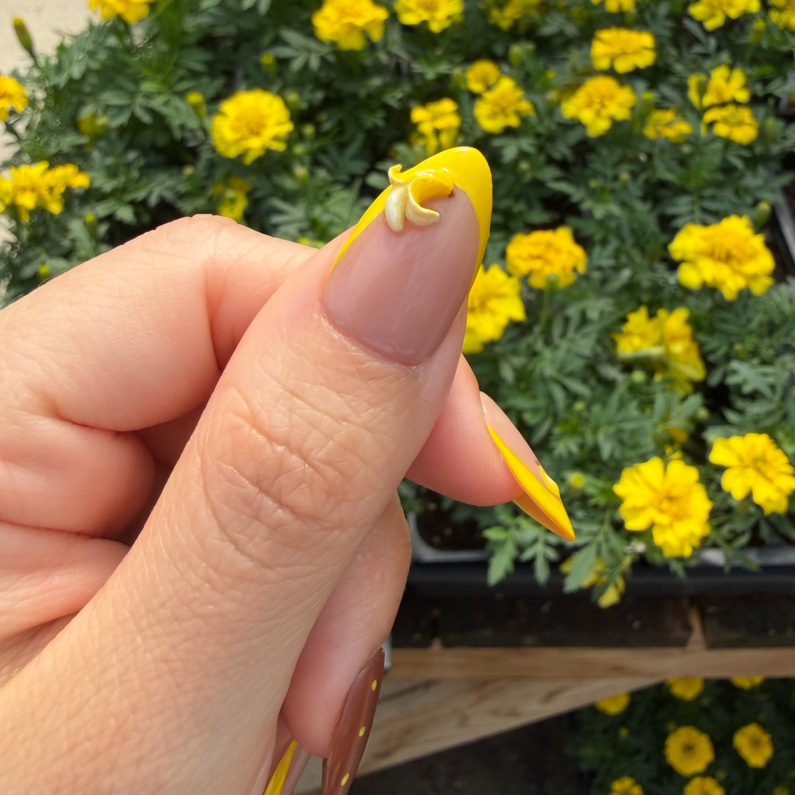 Close-up of the highly detailed 3D sculpted banana charm positioned on a brilliant yellow French tip.
