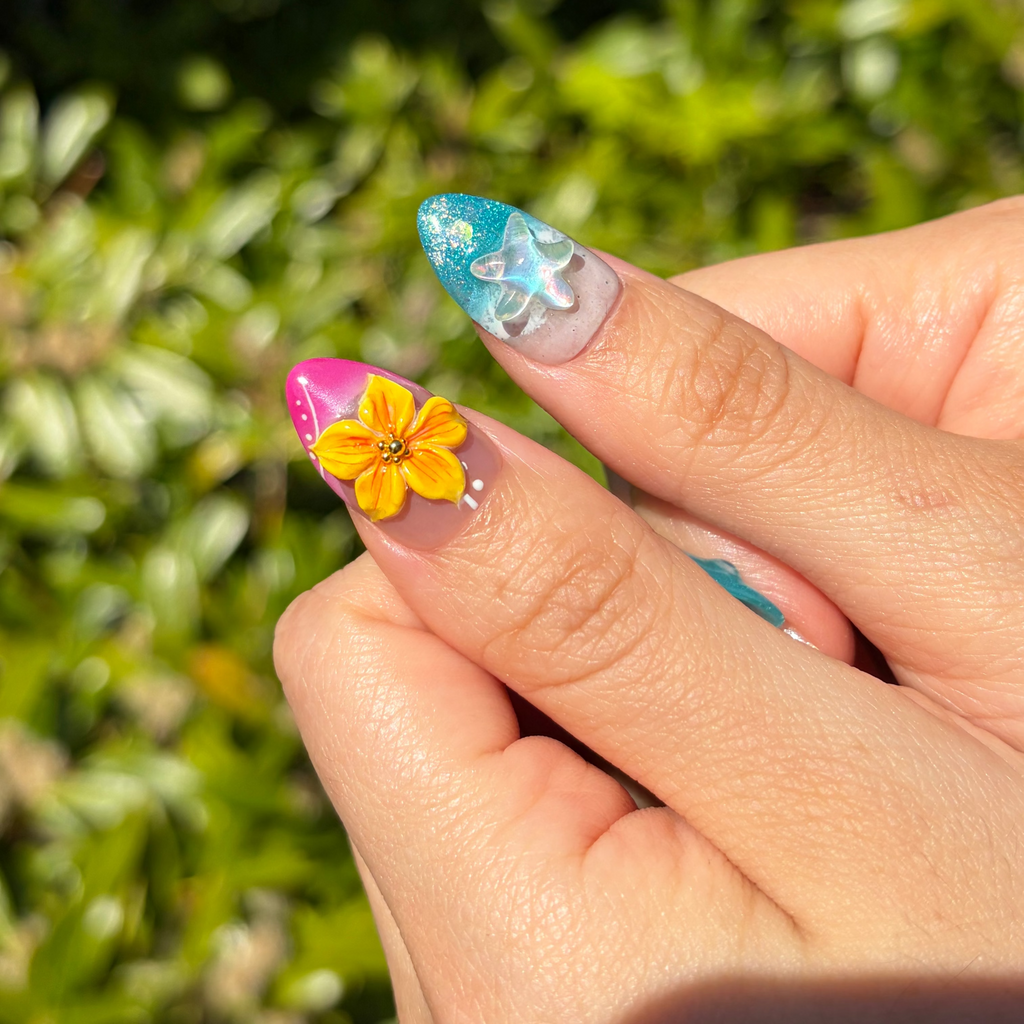 Close-up of thumb nails with Island Muse, Summer 2026 Trends, Ocean-Core Beauty, 3D Flower Nails, Beach Manicure, Hot Pink and Teal Nails.