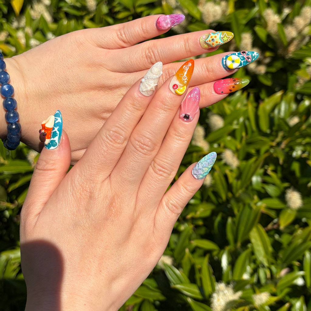 a real person wearing Reusable beach press-on nails, handmade 3D ocean nails, unique sea-themed nail art, ocean swim manicure.