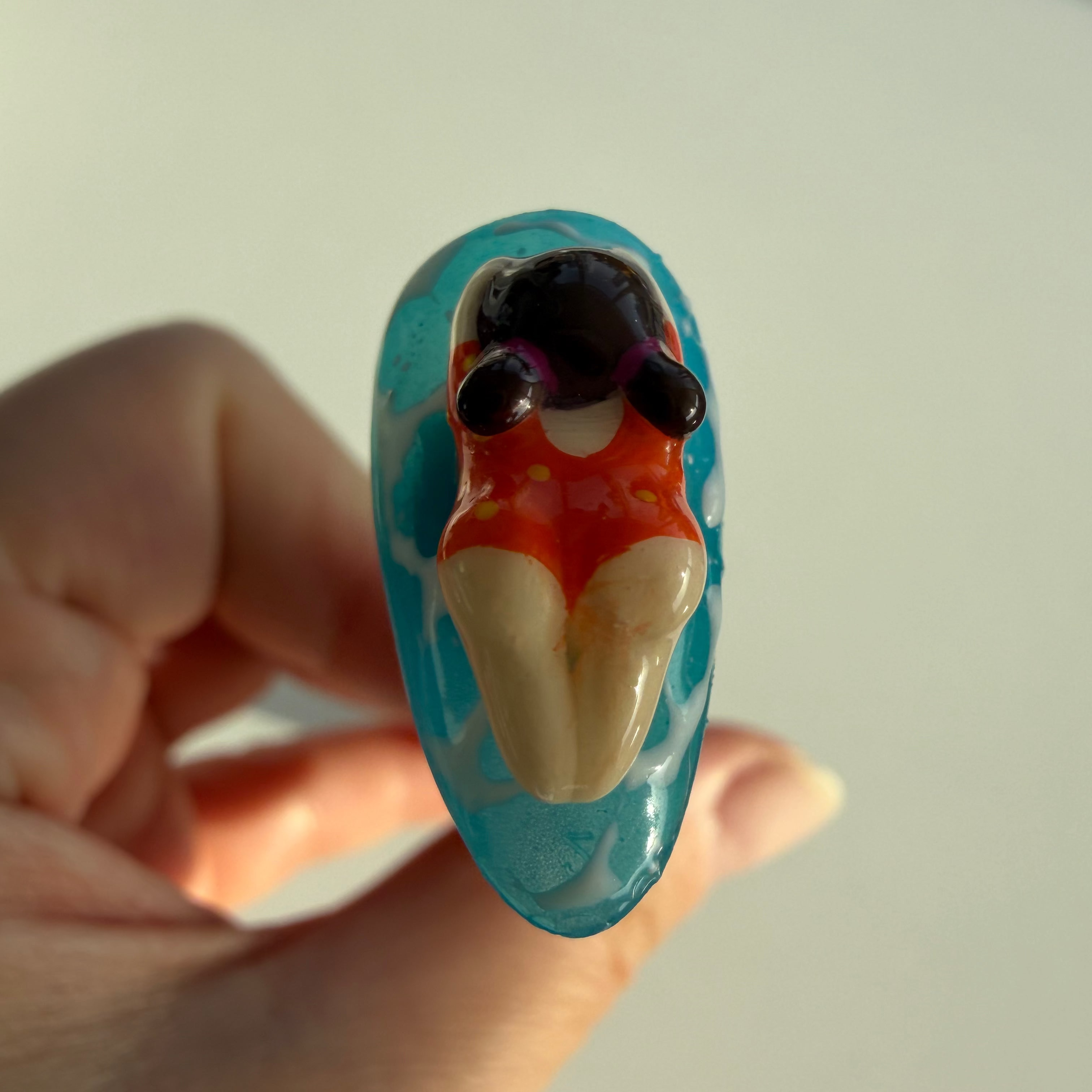overhead view of 3d swimming figures on the press-on nail